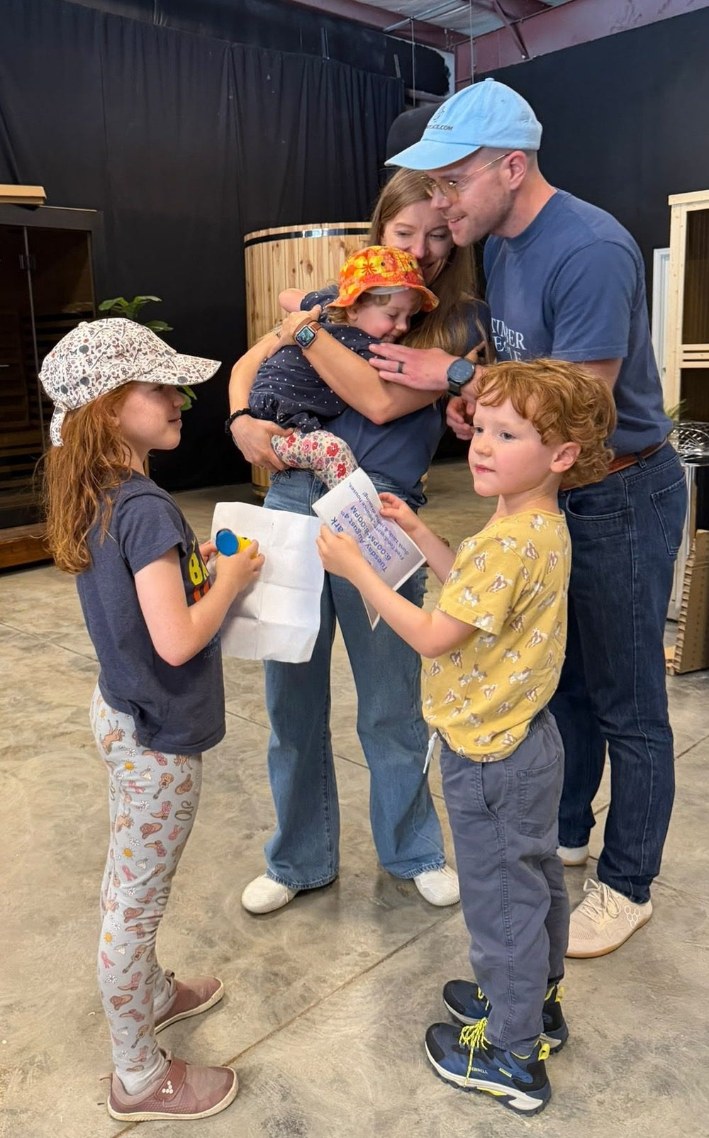 Tim and Laura Marbach with their kids in the shop